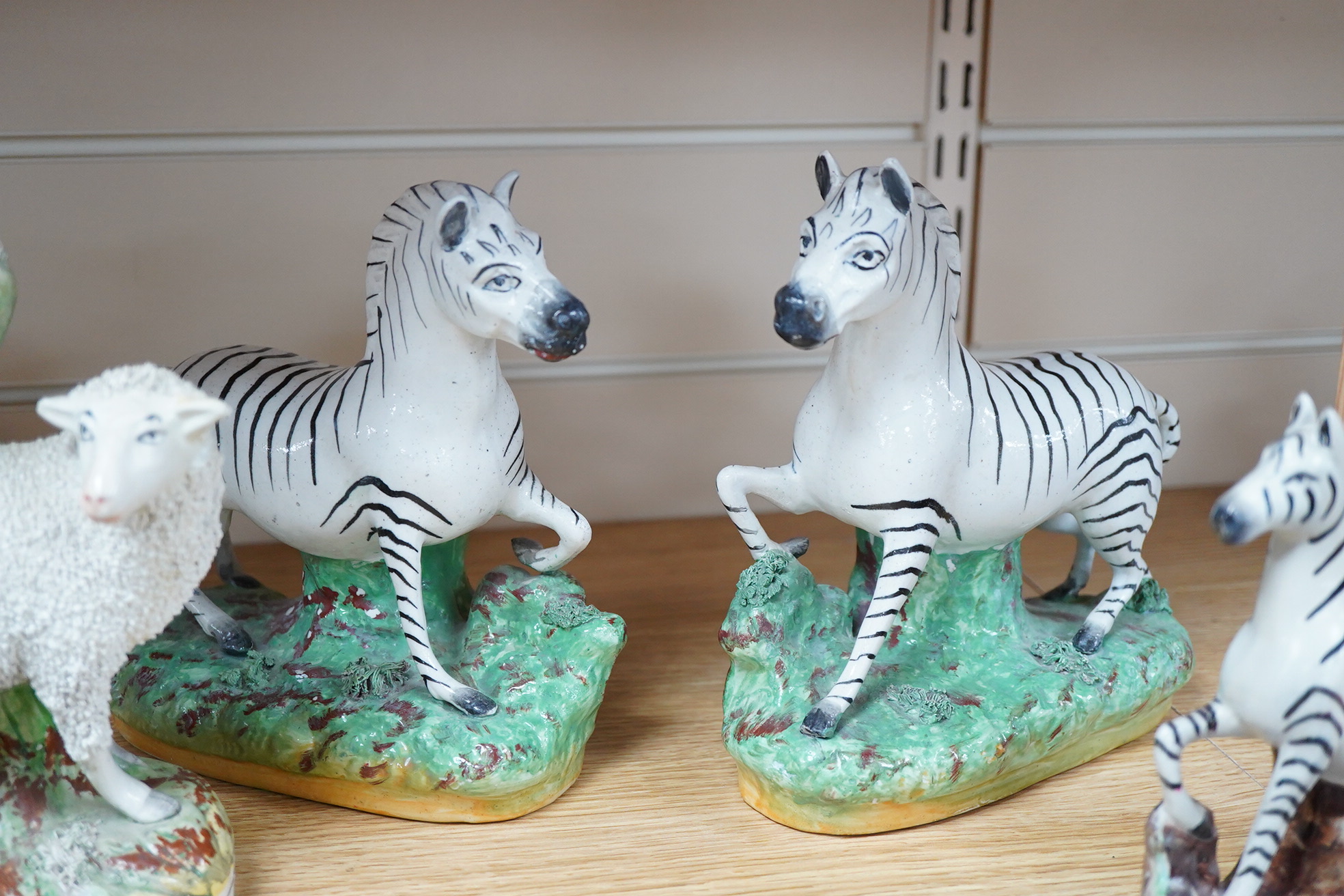 Two pairs of Victorian Staffordshire zebra models and others to include three sheep spill vases, largest 19cm high